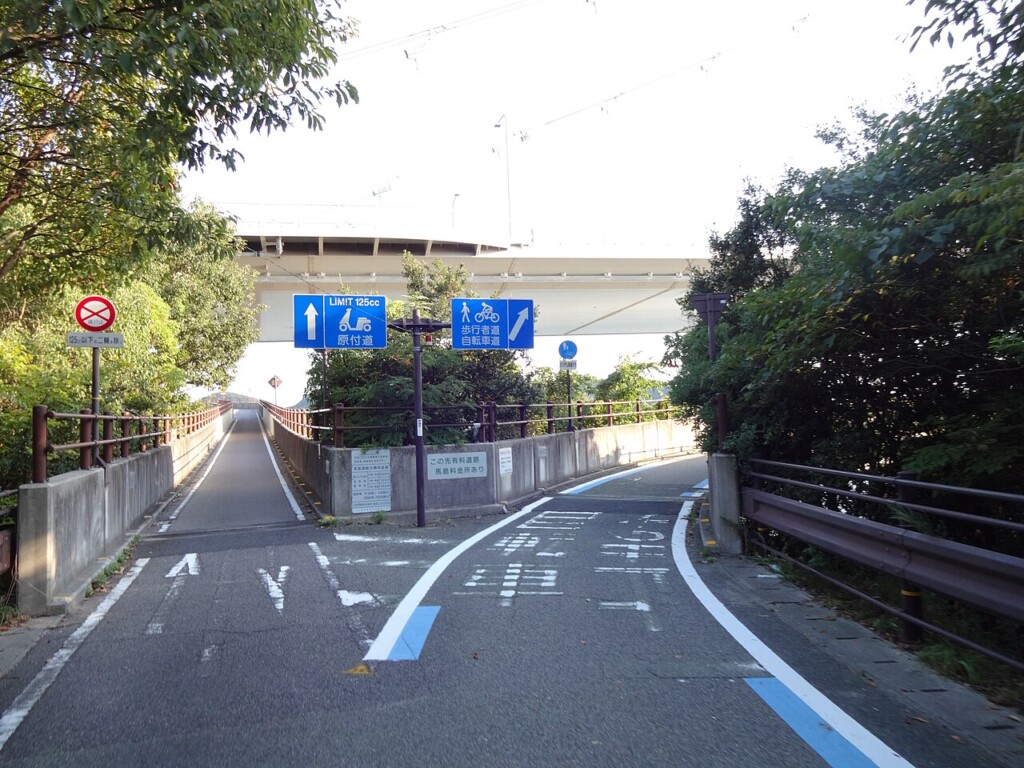 料金所へ向かう高速道路の入口と青い案内標識