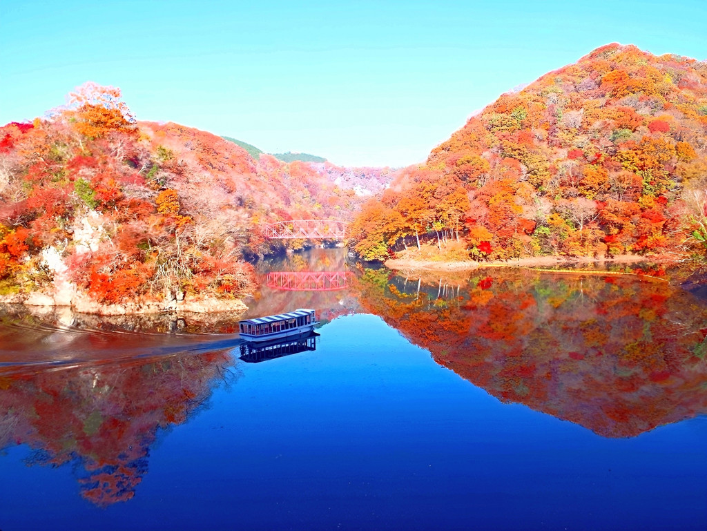 紅葉の山に囲まれた神龍湖の湖面を進む遊覧船