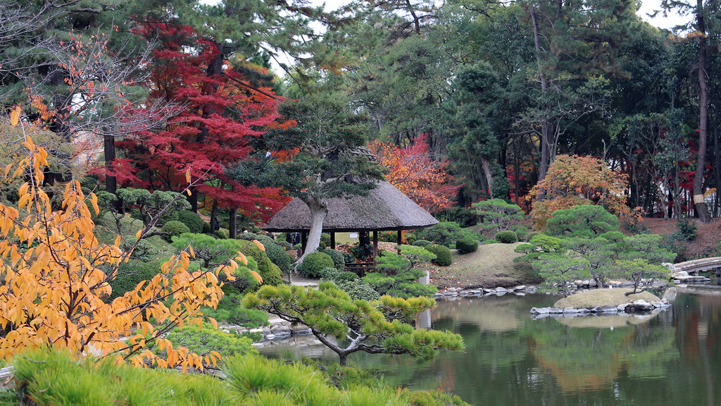 松と紅葉に囲まれた縮景園の茅葺き屋根の茶室